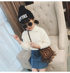Close-up of a leopard print tassel crossbody bag styled with a kid's fashion outfit