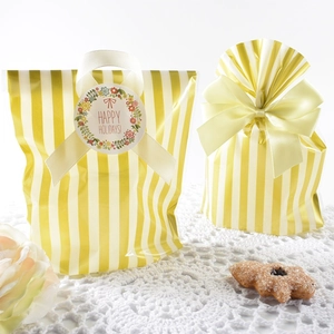 Striped gold-stamped OPP cookie bags with yellow bows and holiday gift tags