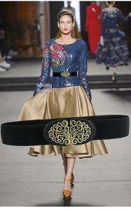 Detail of a wide elastic cinch belt featuring a vintage gold hollowed floral buckle