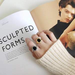 Detailed view of vintage gold and silver rings with oval black onyx and rope-edge finish