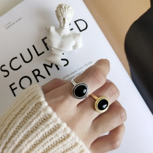 Close-up of retro 925 silver and gold rings with black onyx inlay on model hand