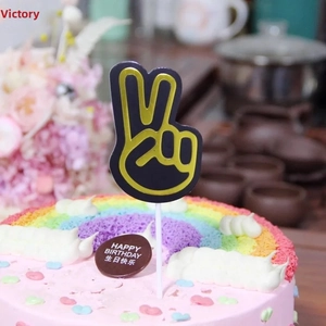Gros plan d'une décoration de gâteau geste de victoire noir et or sur gâteau arc-en-ciel