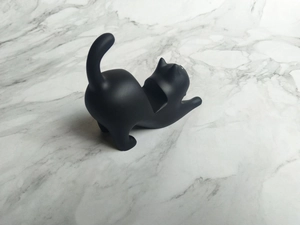 Macro detail of matte black resin cat phone stand showing the secure U-shaped groove design