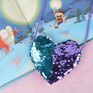 Mini heart-shaped sequin crossbody bag for kids in blue and purple on pink plush background