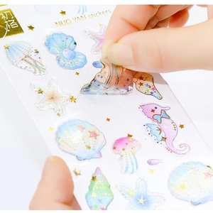 Peeling a holographic laser sea creature sticker featuring a jellyfish and starfish detail