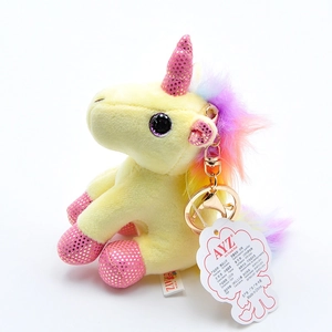 Detail of 12cm yellow unicorn plush keychain with rainbow mane and brand tag