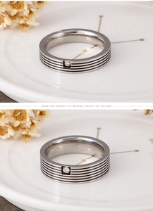 Detailed view of stainless steel ring featuring four black stripes and a center diamond