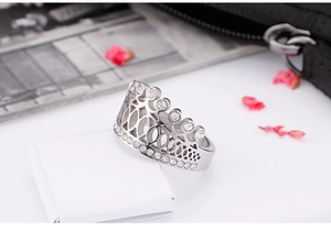 Detailed view of silver crown ring with pavé diamonds on a white gift box