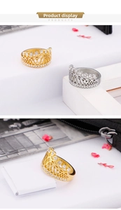 Detail view of gold and silver crown rings with intricate hollow patterns and zircon inlay