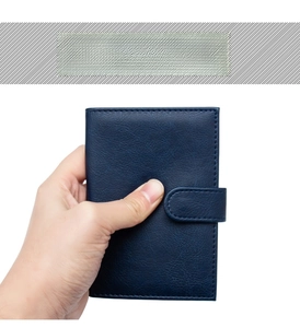 Detail of navy blue PU leather passport holder with buckle and lychee grain texture