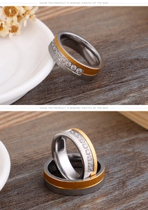 Detail of brushed titanium steel rings with gold plating and embedded zircon stones
