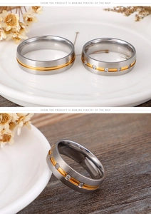 Detail of matte brushed titanium couple rings with gold inlay and five small diamonds