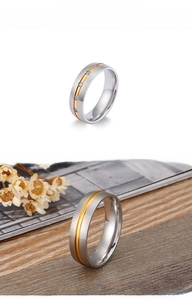 Detail of brushed silver and gold stainless steel rings with minimalist zircon inlay