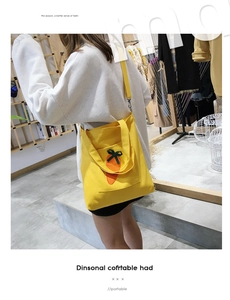 Close-up of yellow canvas shoulder bag featuring a cute orange carrot embroidery detail