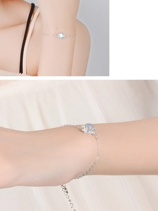 Detailed close-up of adjustable silver chain bracelet featuring a round moonstone inlay