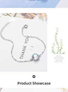 Detail view of crown-shaped moonstone bracelet on white card with floral background