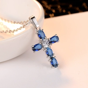 Cross necklace with blue zircon pendant on silver chain for women in a minimalist design