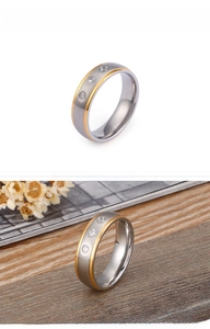 Detail eines zweifarbigen Edelstahlrings mit drei runden Zirkonia-Steinen in Matt