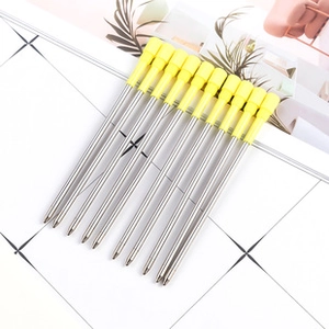 Detailed set of silver metal ballpoint pen refills with yellow caps on grid paper