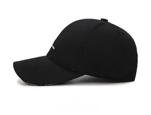 Side view of black cotton baseball cap showing white embroidery detail on brim