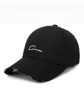 Detail of white Grace embroidery and Fashion text on a black cotton baseball cap
