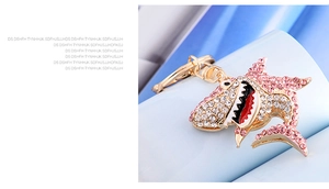 Detail of shark keychain featuring pink and gold rhinestones with polished metal finish