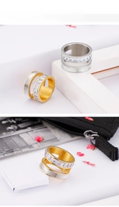 Close-up of triple-layered titanium ring with polished gold silver bands and zircon stones