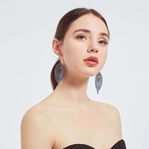 Macro detail of leaf-shaped iridescent mesh earrings worn by a model on a white backdrop