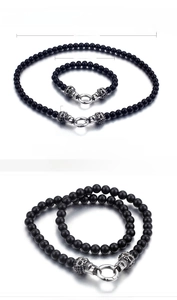 Detail of punk skull bracelet and necklace set made of stainless steel and black glass beads