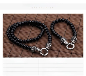 Macro shot of punk black glass beads bracelet set with silver stainless steel skulls