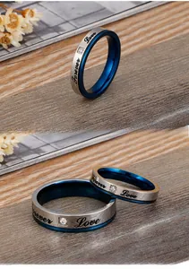 Detailed macro view of Forever Love engraved silver and blue couples rings with zircon