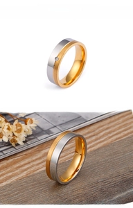 Détail macro d'une bague bicolore en titane avec finition dorée brossée et zircon serti