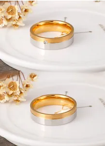Gros plan de bagues de couple bicolores en acier titane avec finition brossée dorée