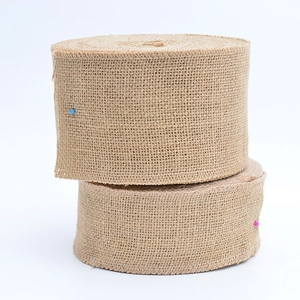 Detail of natural jute ribbon rolls with textured burlap weave on white background