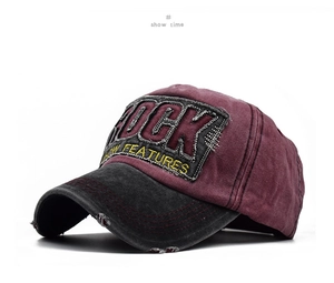 Detail of burgundy baseball cap showing ROCK embroidery and distressed frayed edges