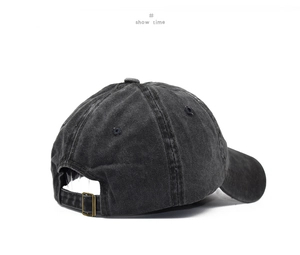 Detail of the adjustable metal buckle and stitching on a washed black baseball cap