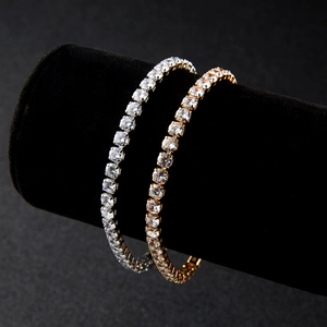 Sparkling gold and silver tennis bracelets with heart pendants on black velvet stand