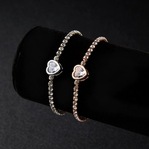 Detailed view of silver and rose gold cubic zirconia bracelets with heart pendants