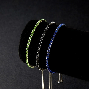 Detailed view of silver bracelets with green, black, and blue zircon heart pendants
