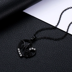 Gros plan d'un pendentif cœur noir mat avec lettrage Mom et cristaux blancs sur cuir noir