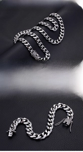 Macro detail of silver stainless steel Cuban link chain with sparkling CZ stones on clasp