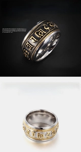 Macro view of wide stainless steel spinning ring with gold mantra relief and two-tone finish