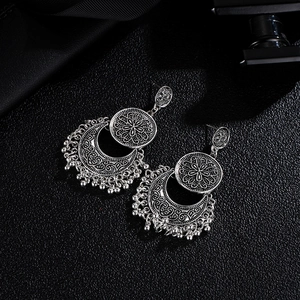 Vintage bohemian crescent moon earrings with hollow patterns and silver bead tassels