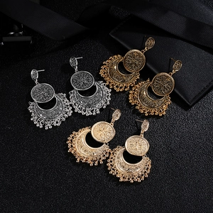 Detail view of retro Bohemian earrings with hollow moon patterns and tassel beads