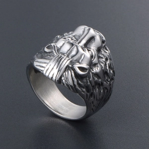 Vintage stainless steel lion head ring with detailed engraving on a dark background