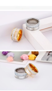 Detail of wide stainless steel rings with shell inlay and square-cut zircon stones