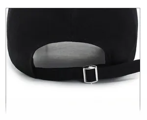 Detail of adjustable metal buckle and strap on a black cotton twill baseball cap