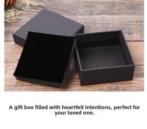 Vue détaillée d'une boîte à bijoux carrée en papier kraft noir sur fond en bois naturel