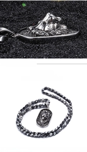Macro detail of silver lion head embossed pendant and round bead chain necklace for men