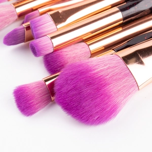 Macro detail of soft pink-purple synthetic bristles and rose gold ferrule of makeup brushes